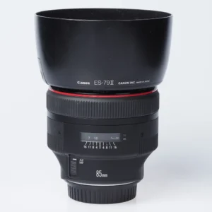 Canon EF 85mm f1.2 II L USM -objektiivi mustana, kuvassa näkyy kiinnitetty ES-79 II -vastavalosuoja ja 85mm-merkintä rungossa