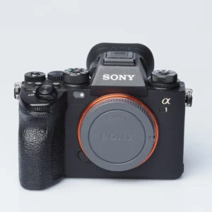 Sony A1 -järjestelmäkamera edestä kuvattuna, runkotulppa paikallaan ja kaulahihnan kiinnityslenkit näkyvissä