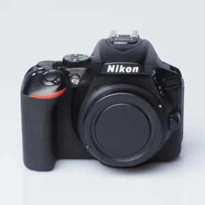 Nikon D5600 -järjestelmäkameran runko edestä kuvattuna, runkotulppa paikallaan