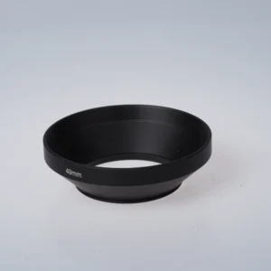 Musta metallinen 49mm vastavalosuoja kuvattuna viistosti ylhäältä, kierreosa näkyvissä